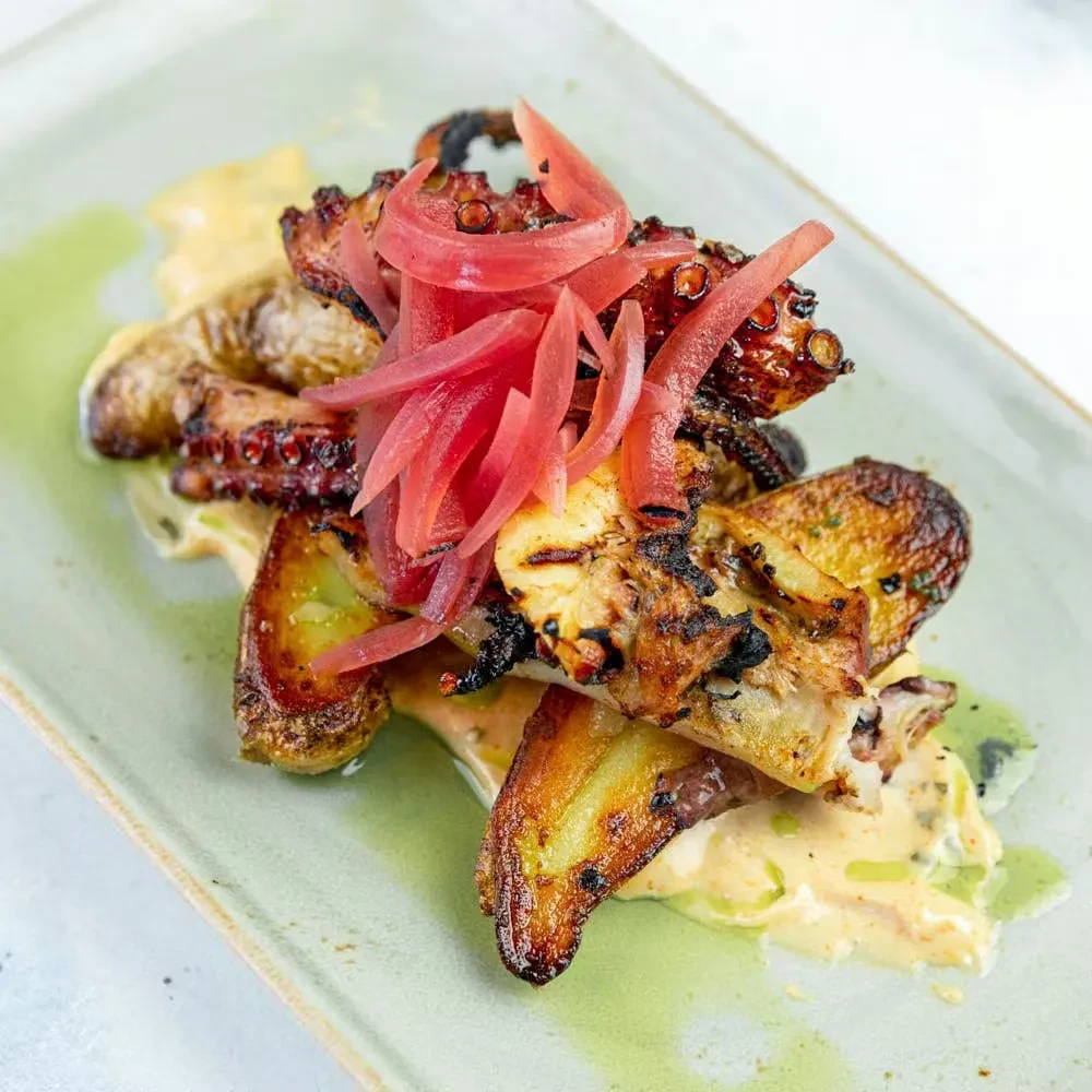 Grilled octopus, crispy potatoes, creamy sauce, and pickled onions.