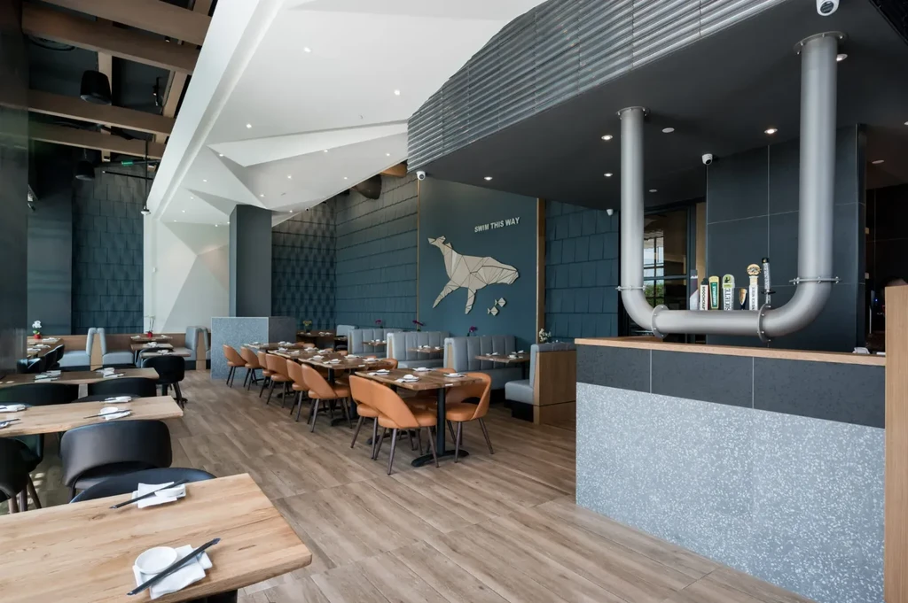 Modern restaurant and bar interior with geometric whale art and taps.