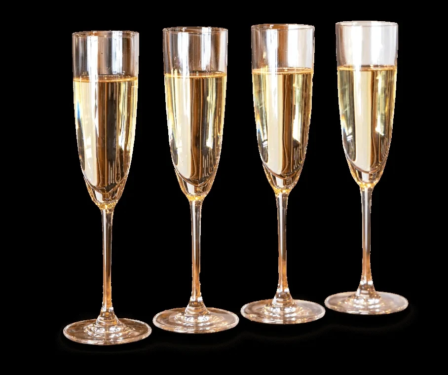 Aligned champagne flutes filled with sparkling golden liquid on black.