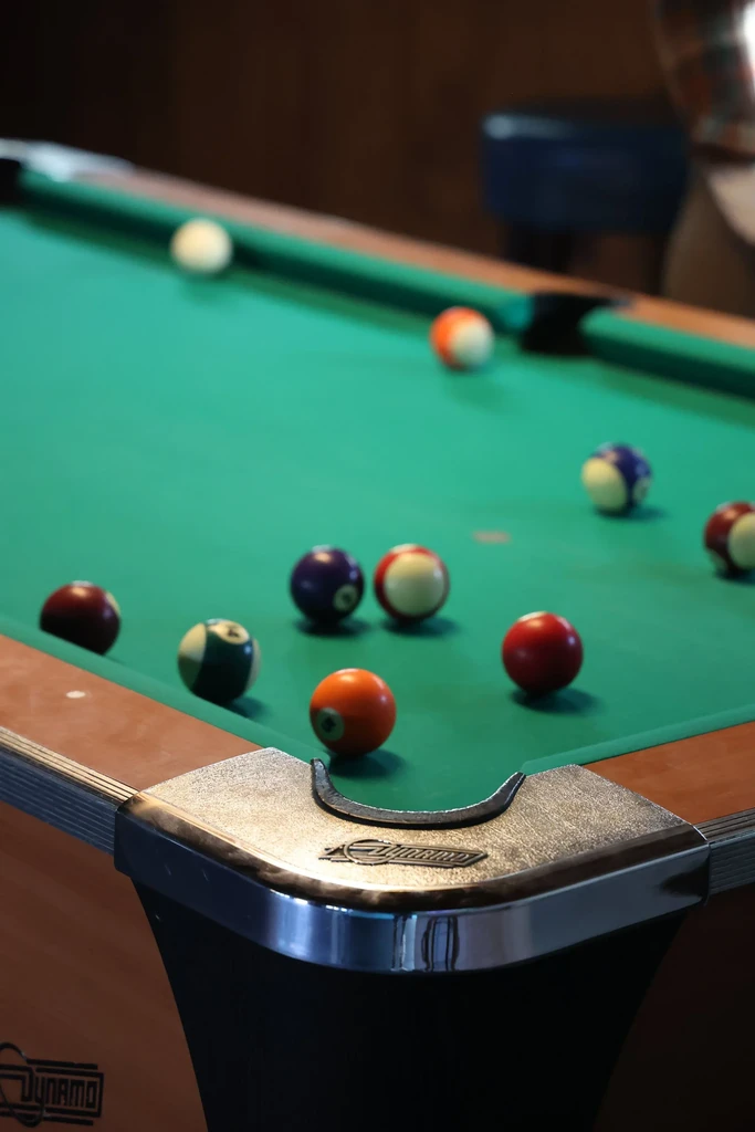 Close-up of Dynamo pool table with scattered billiard balls.