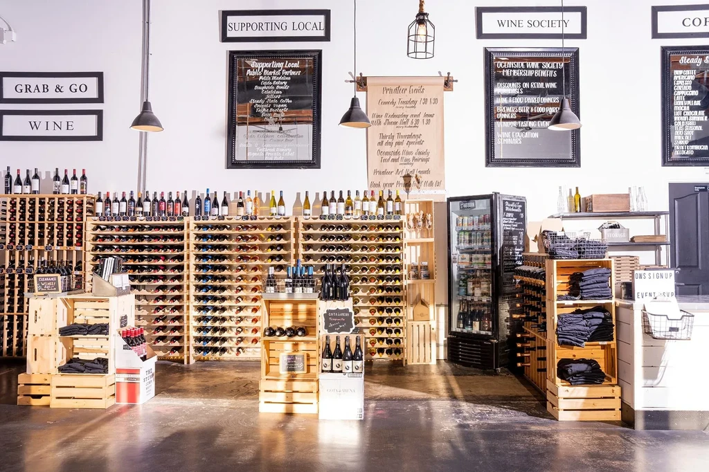 Modern wine store with bottles, wooden racks, and informational signs.