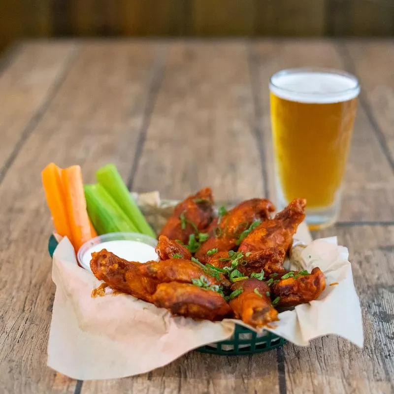 Saucy buffalo chicken wings, celery, carrots, dipping sauce, and beer.