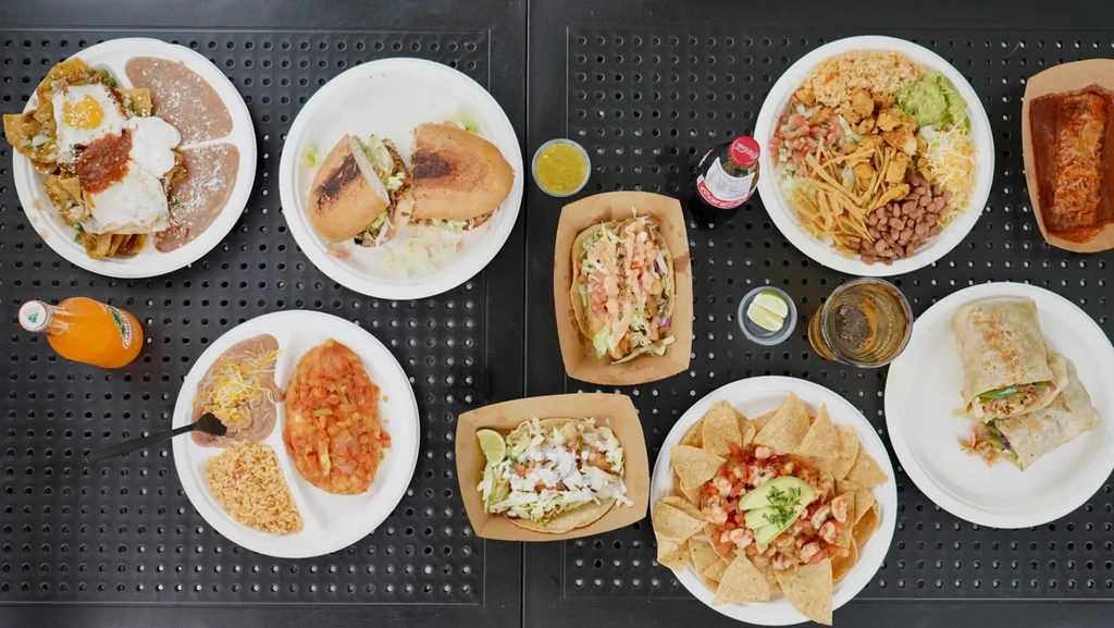 Generous overhead spread: Mexican chilaquiles, tacos, burritos, nachos, and drinks.