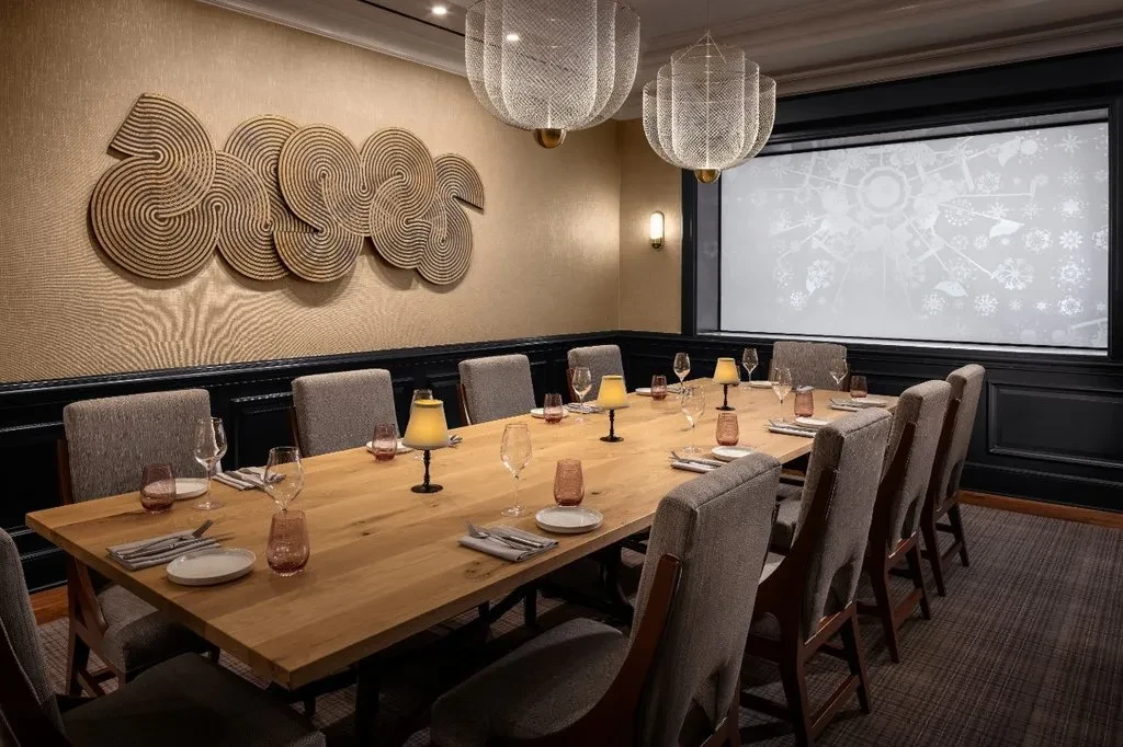 Private dining room: long table set, unique rope art, ornate lights.