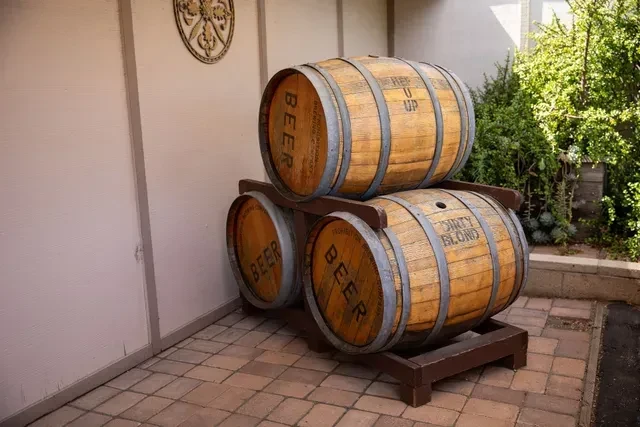 Stack of three wooden beer barrels with 'BEER' and 'DIRTY BLOND' visible.
