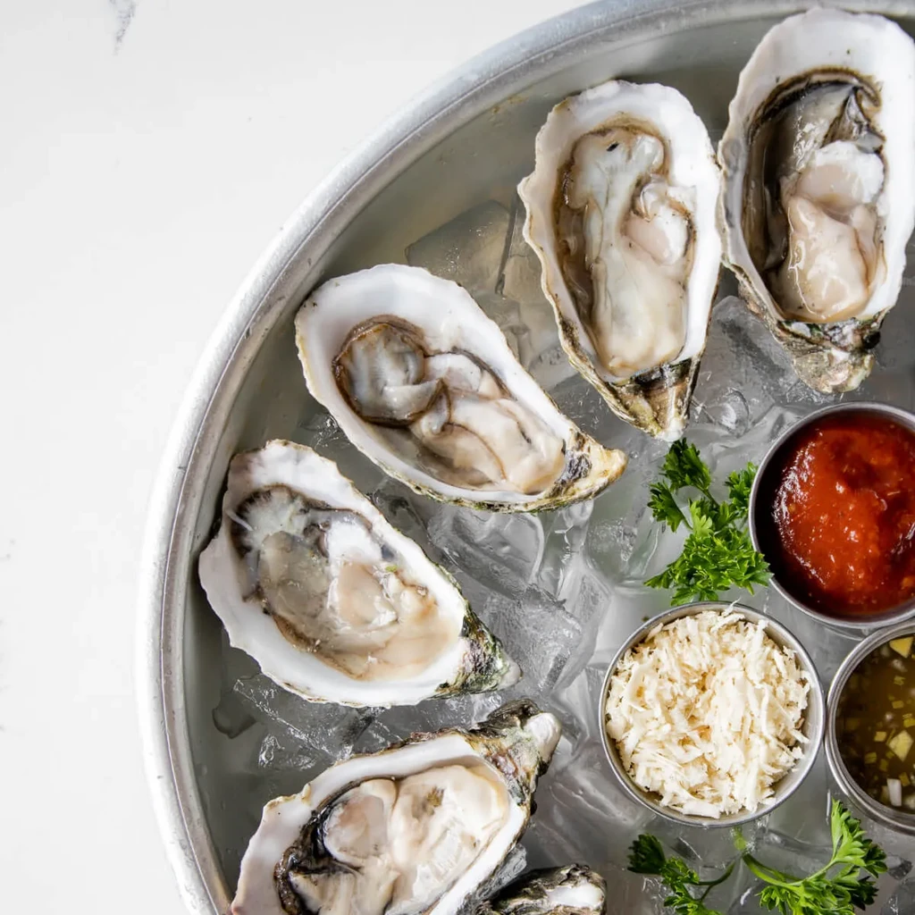 Six plump oysters on ice with cocktail, horseradish, and mignonette.