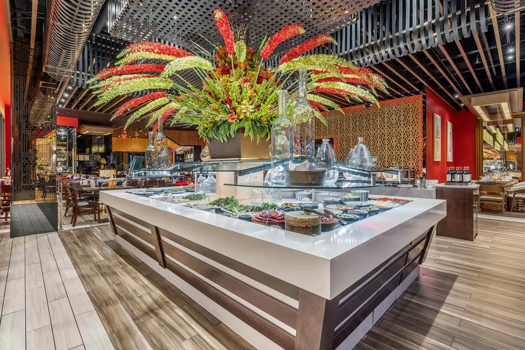 Upscale restaurant buffet with vibrant floral centerpiece and fresh food.