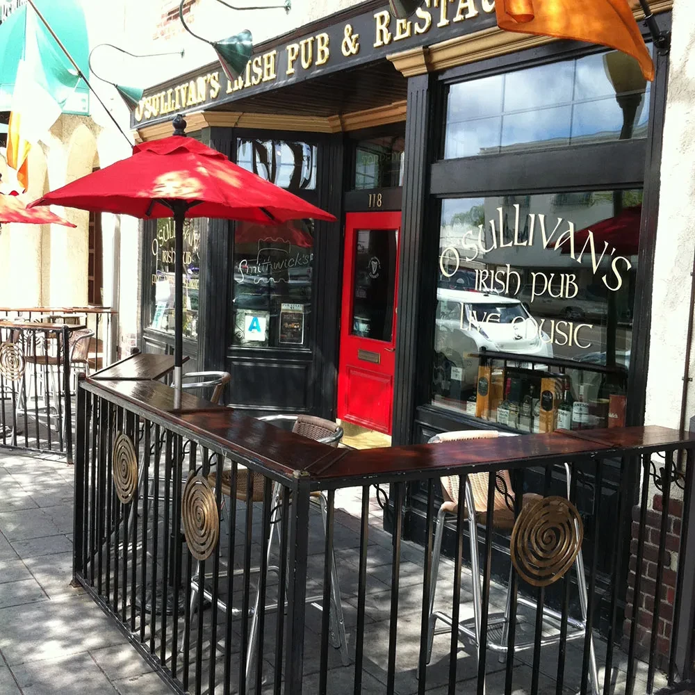 O'Sullivan's Irish Pub with red door, large windows, and patio.