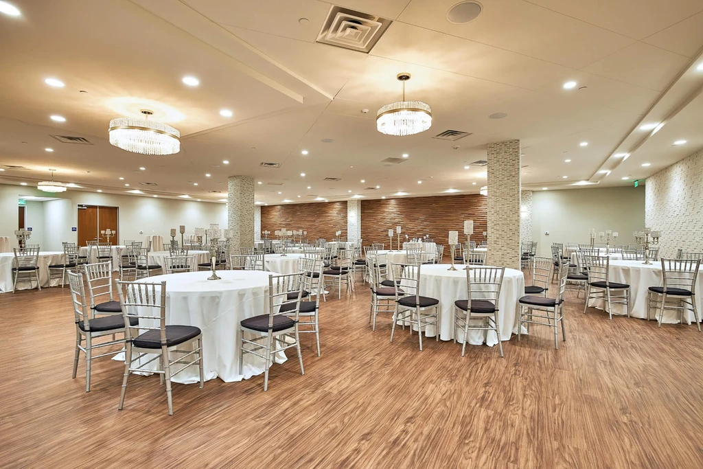 Empty, elegant banquet hall with formal tables and crystal chandeliers.