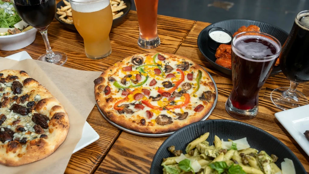 Overhead shot of a rustic table laden with diverse food and drinks.