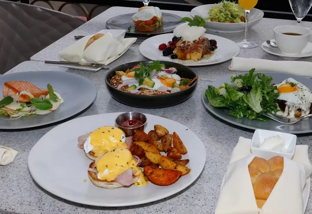 Vibrant restaurant table displays diverse, meticulously plated breakfast and brunch dishes.