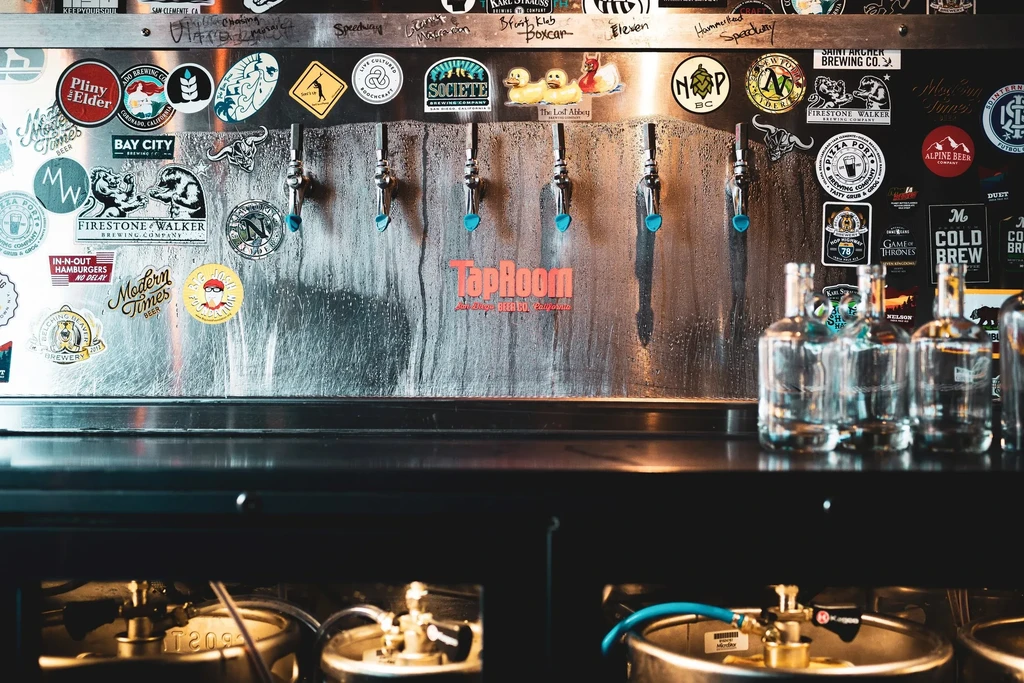 Beer taps, brewery stickers, and kegs at TapRoom San Diego Beach.