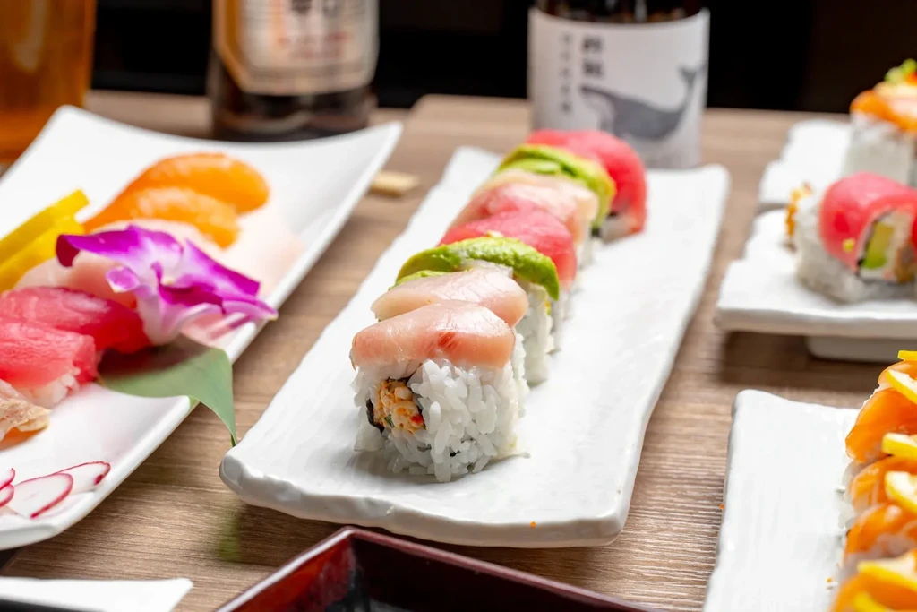 Vibrant sushi and sashimi artfully arranged on a wooden table.