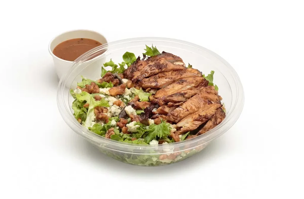 Grilled chicken salad with blue cheese, pecans, and side dressing.