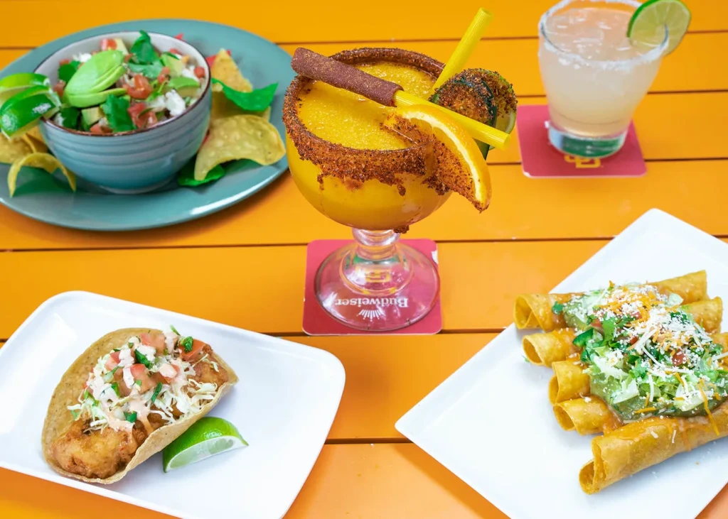 Vibrant spread of Mexican food, tacos, taquitos, and margaritas.