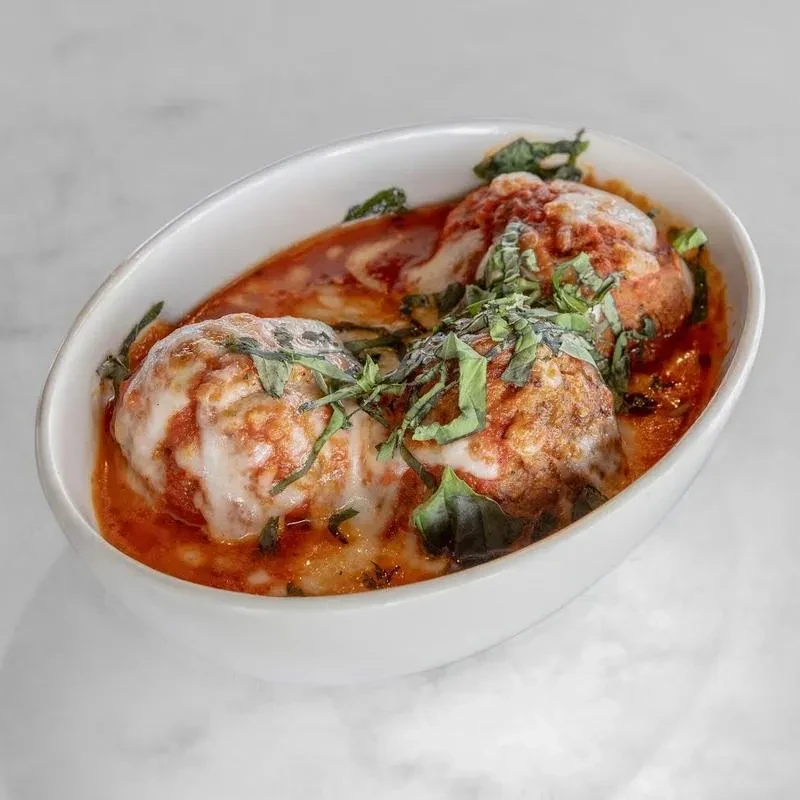 Three large meatballs, red sauce, melted cheese, and fresh basil.