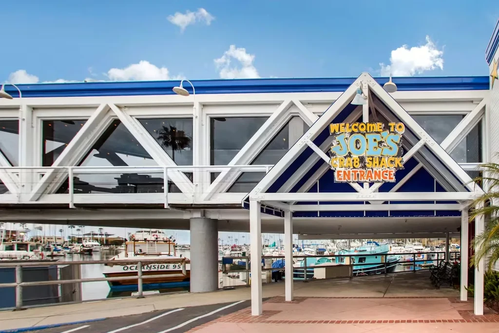 Welcome to Joe's Crab Shack entrance sign above a marina.