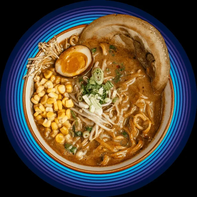 Vibrant top-down view of a ramen bowl with pork, egg, corn, sprouts.