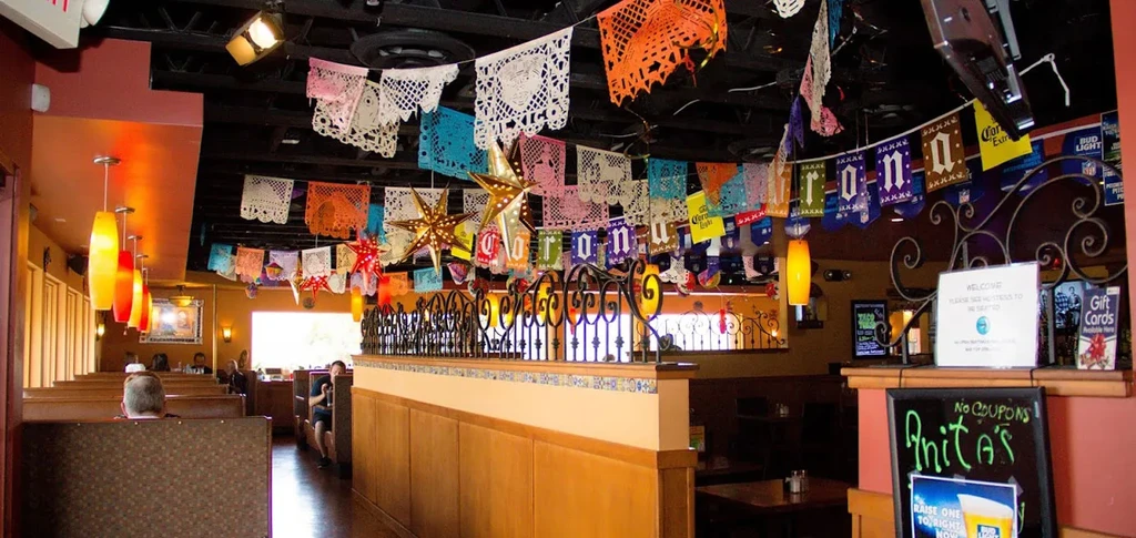 Festive Mexican restaurant interior with colorful papel picado banners and star lanterns.