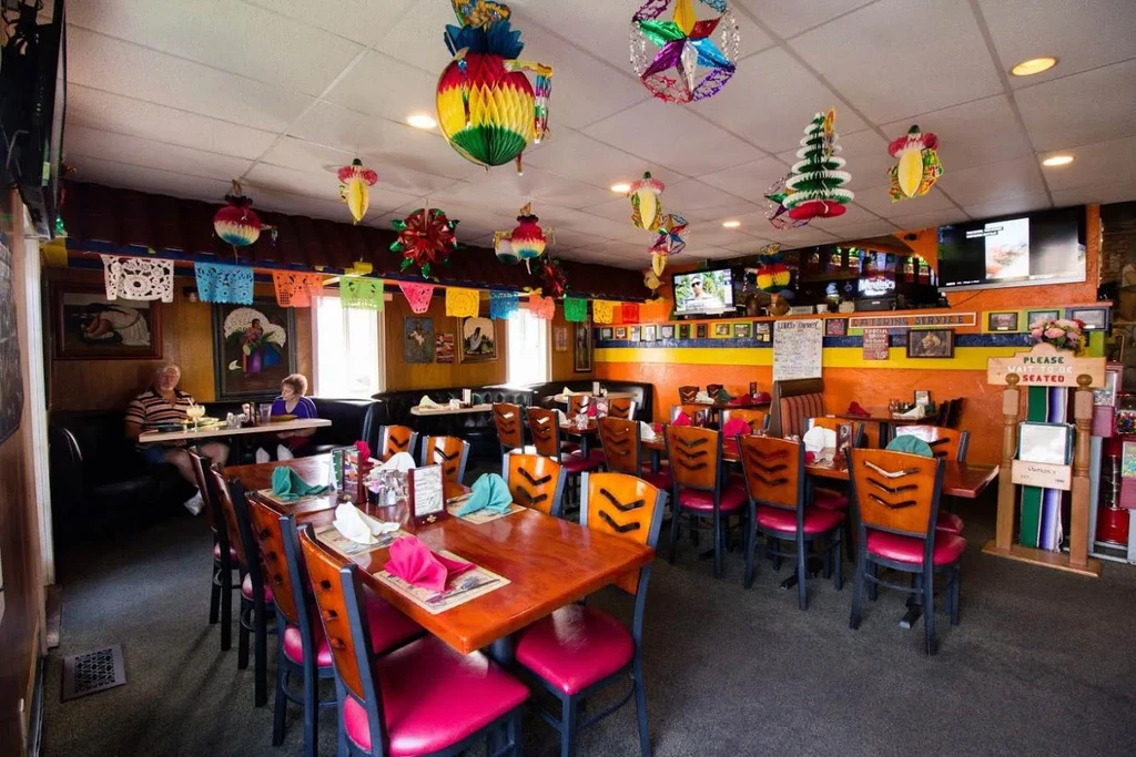 Vibrant, colorful Mexican restaurant interior with festive papel picado.