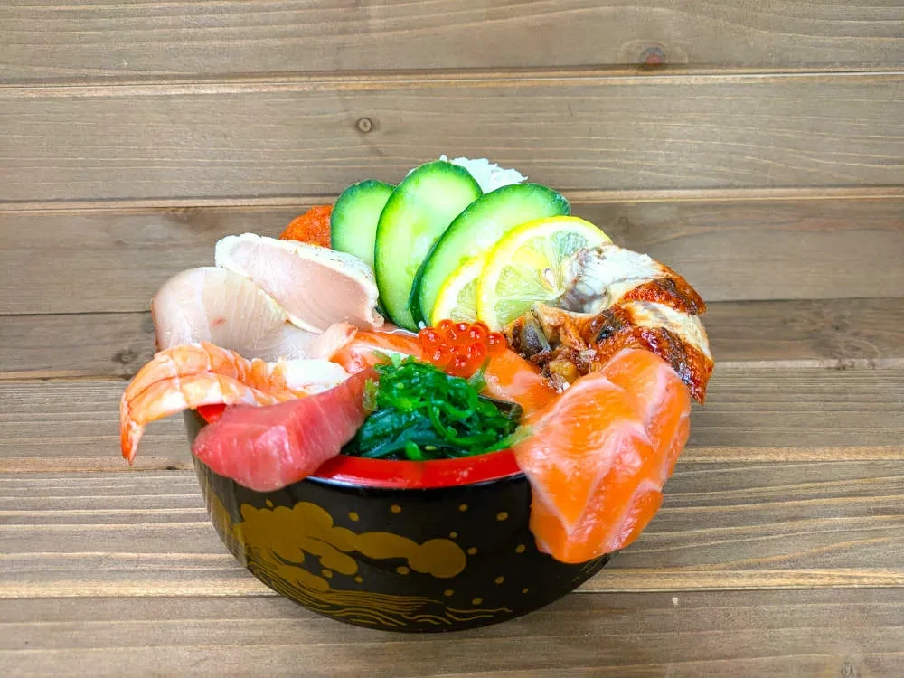 Colorful chirashi don bowl with various fish, roe, and seaweed.