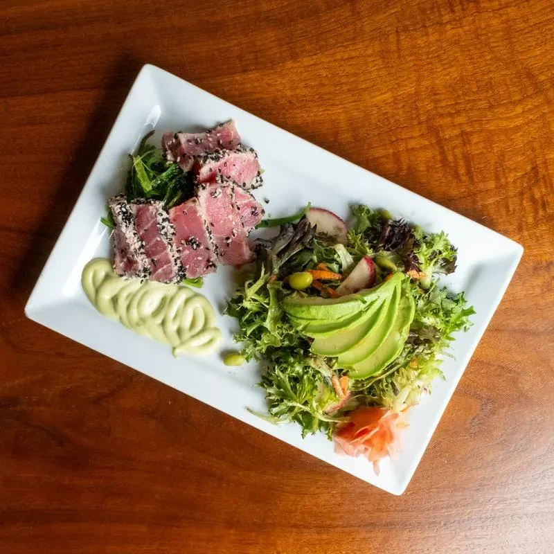 Seared tuna with sesame crust, green salad, avocado, and ginger.