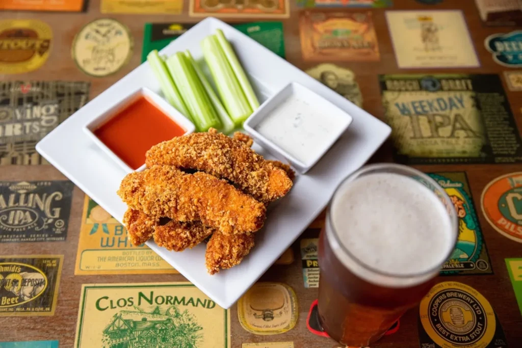 Crispy chicken tenders, two sauces, celery, and a frothy beer.