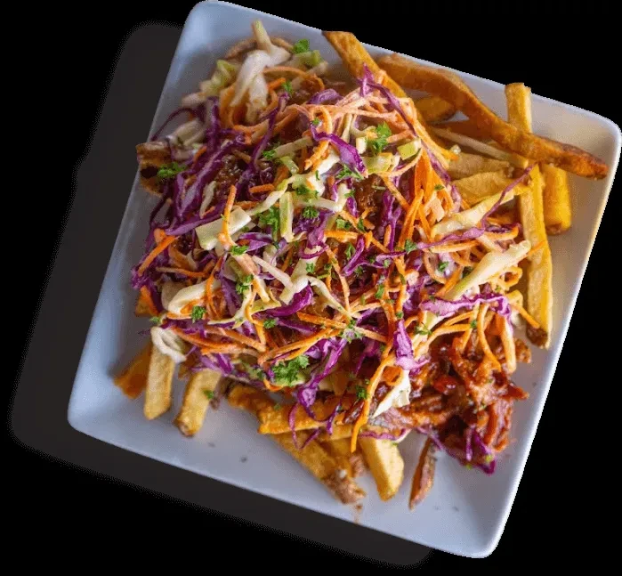 Rectangular plate of loaded fries, pulled meat, and colorful coleslaw.
