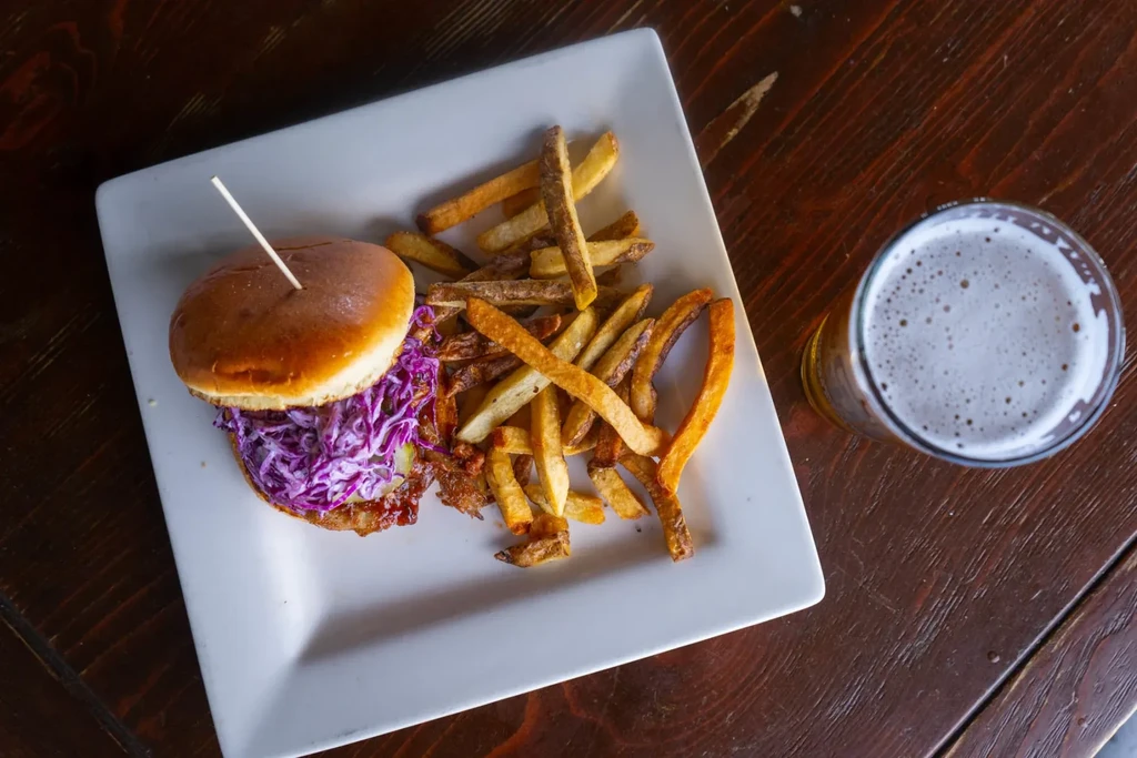Burger with purple coleslaw, hand-cut fries, and a beer.