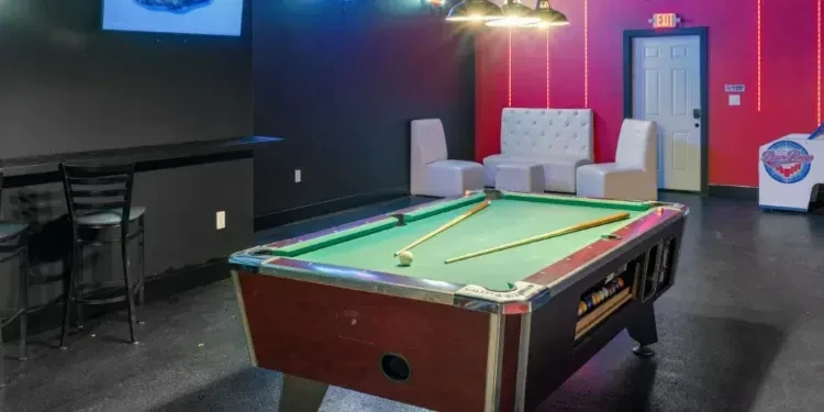 Vibrant retro entertainment area with a pool table and arcade game.