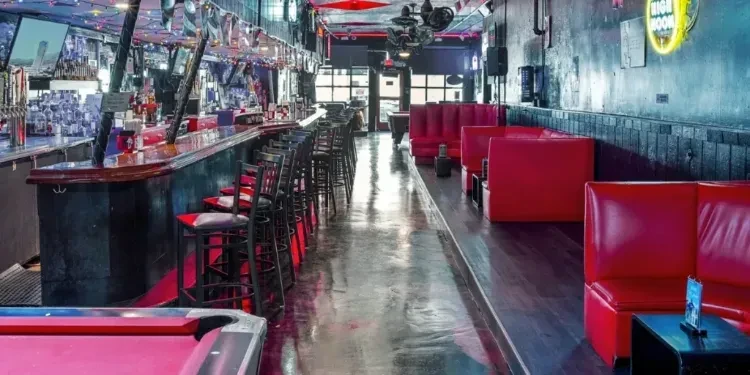 Modern bar interior, long counter, red booths, pool table.