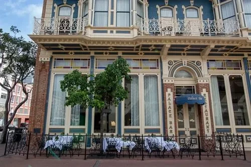 Ornate multi-story Palace Bar & Restaurant with sidewalk dining.