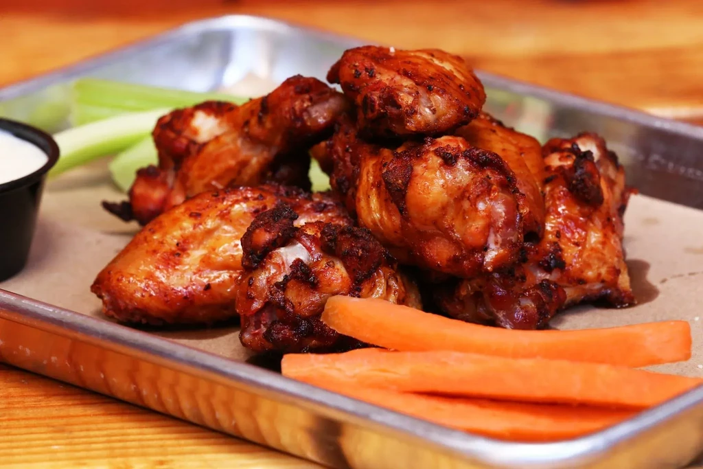 Roasted chicken wings, celery, carrots, and dipping sauce.
