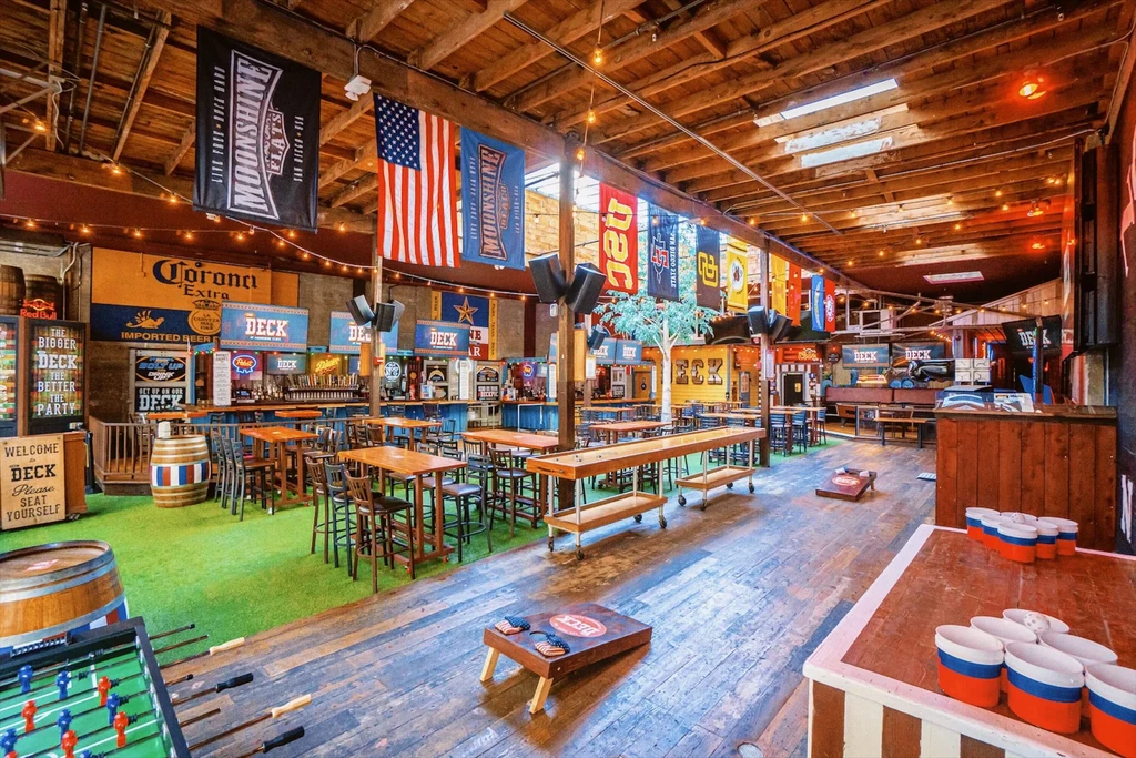 Moonshine Flats' empty rustic bar interior with games and multiple bars.