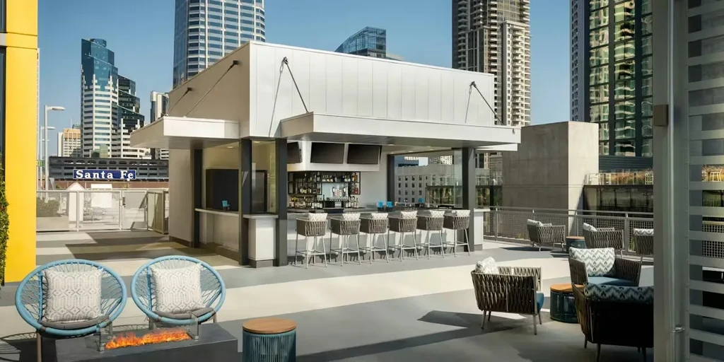 Modern, empty rooftop bar and lounge overlooking a vibrant city skyline.