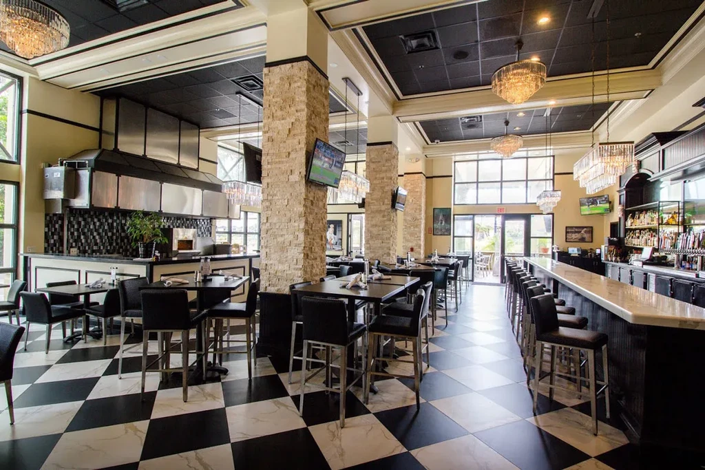 Empty contemporary restaurant and bar with checkered floor and open kitchen.