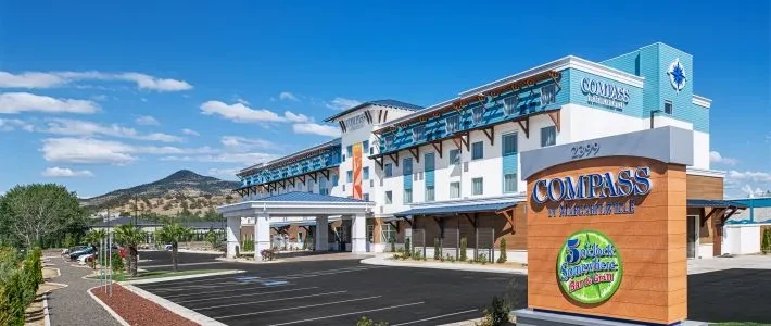 COMPASS by Margaritaville hotel exterior with tropical design and monument sign.