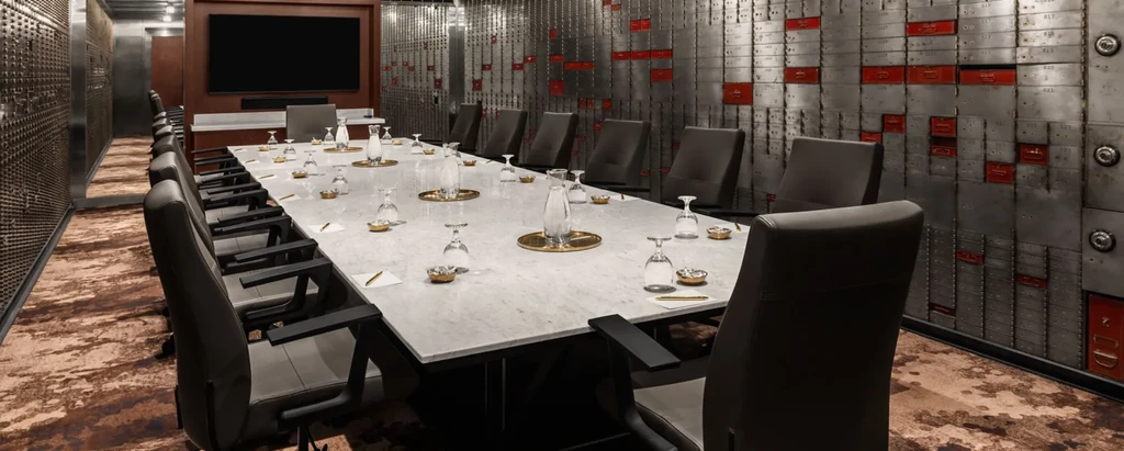 Sophisticated private meeting room with a set table and unique walls.