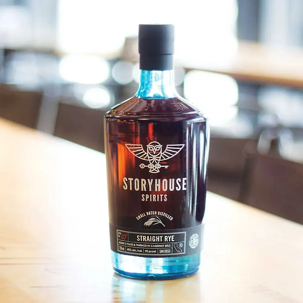 Storyhouse Spirits Straight Rye bottle, dark glass, blue base and neck.