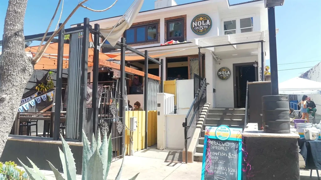NOLA ON 5TH restaurant exterior with orange-awned patio and weekend specials.