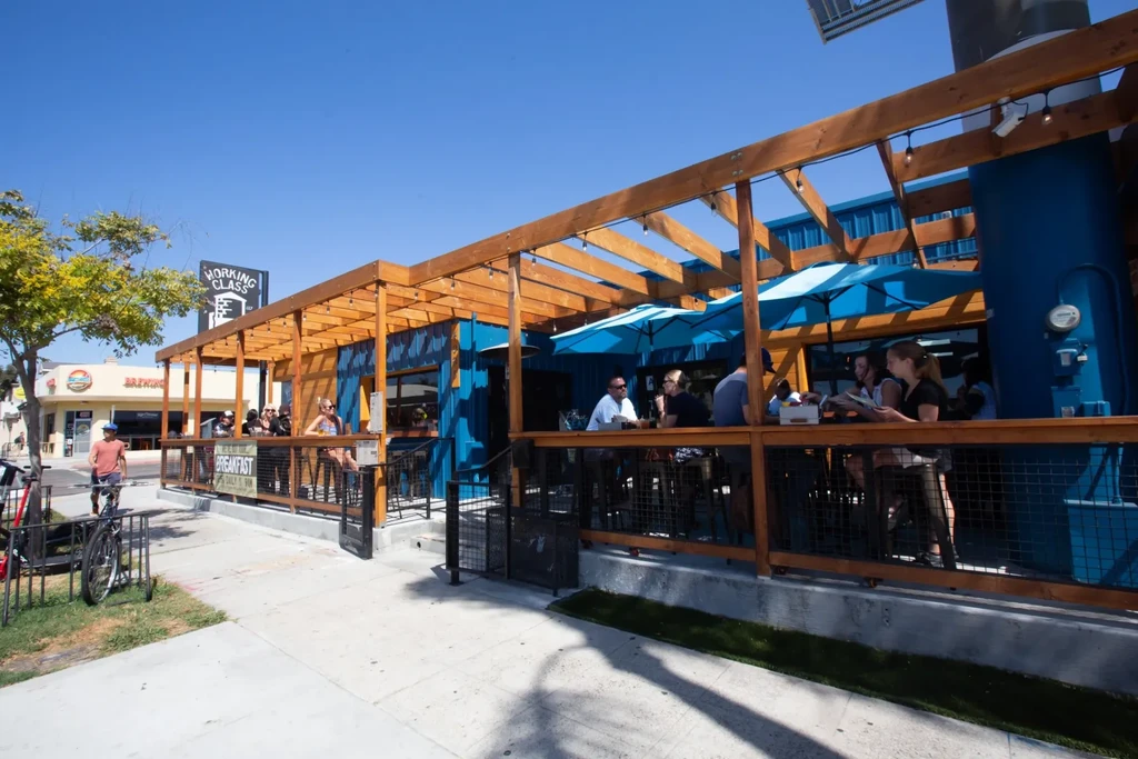 Blue container restaurant patio with umbrellas on a sunny day.