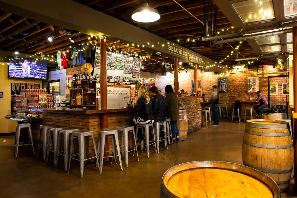Interior of Belching Beaver brewery with a long bar and patrons.