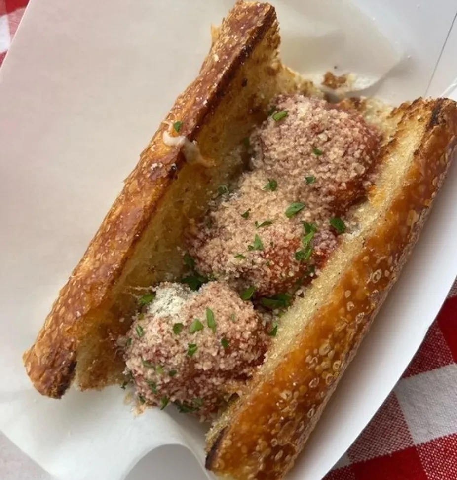 Toasted meatball sub with sauce, cheese, and fresh parsley.