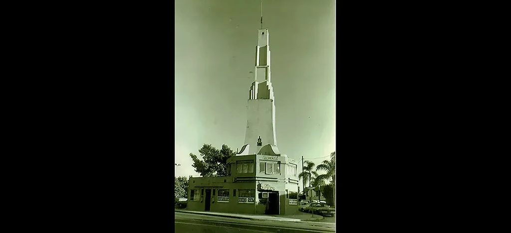 Monochrome photo of Art Deco building, tiered tower, 'Dining Room' sign.