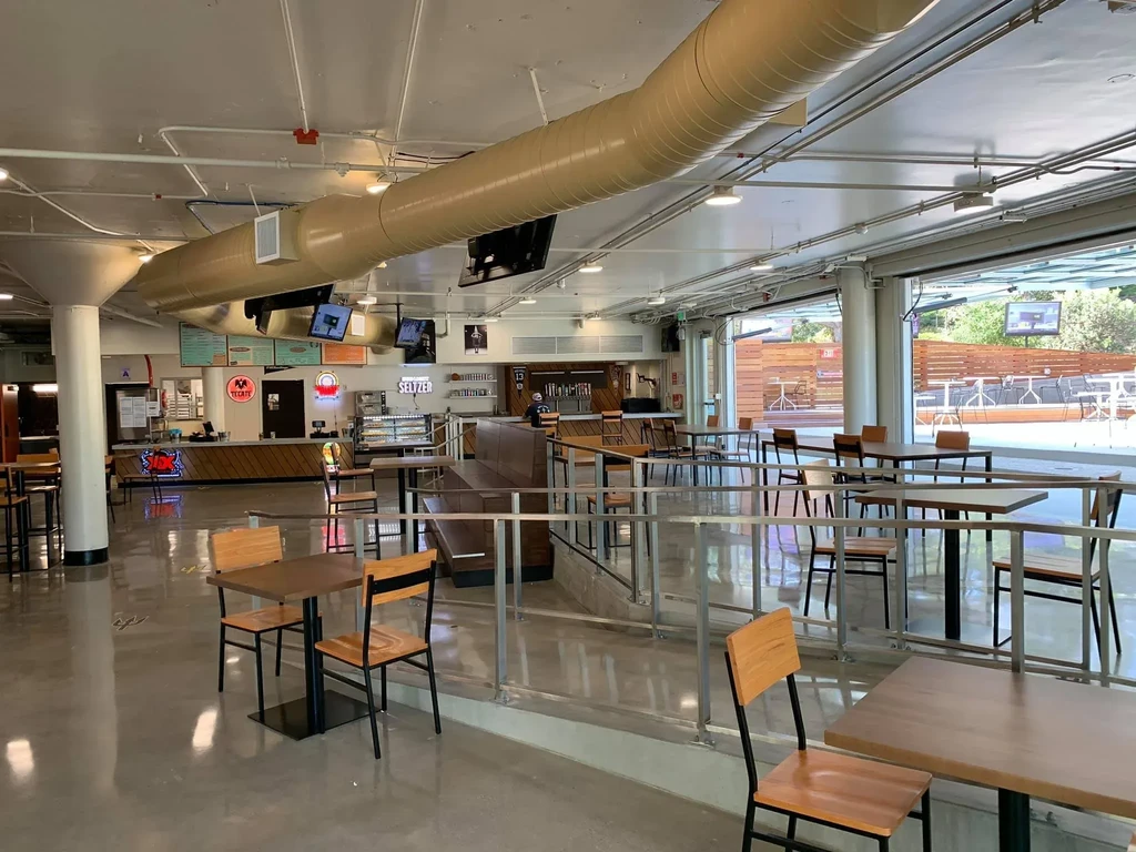 Bright, modern restaurant with industrial decor, bar, and outdoor patio.
