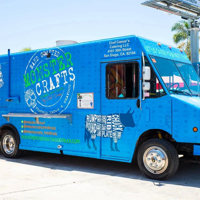 Bright blue Monster Crafts food truck with skull and bull graphics.