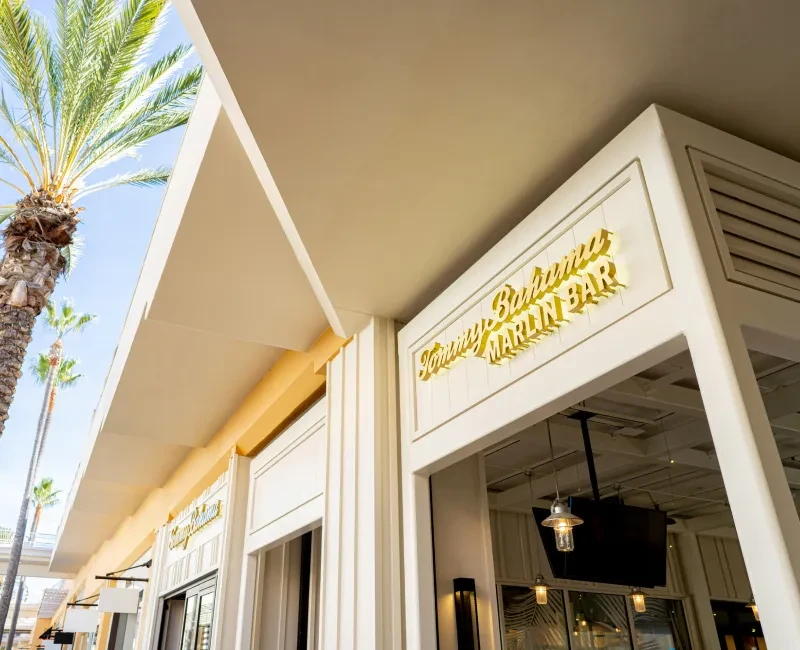 Modern Tommy Bahama Marlin Bar building exterior with palm trees.