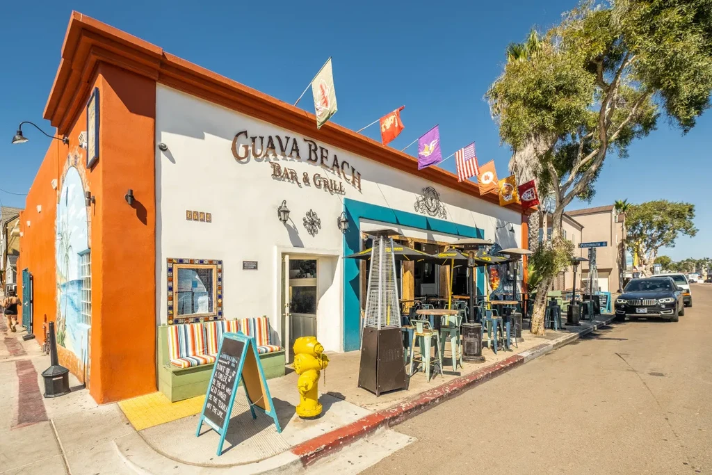 Colorful Guava Beach Bar & Grill exterior with beach mural and outdoor seating.