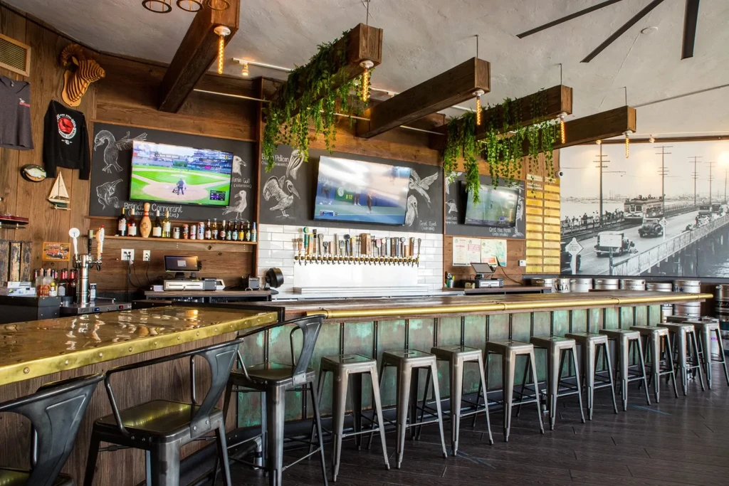 Modern gastropub bar with multiple beer taps and sports on TV.
