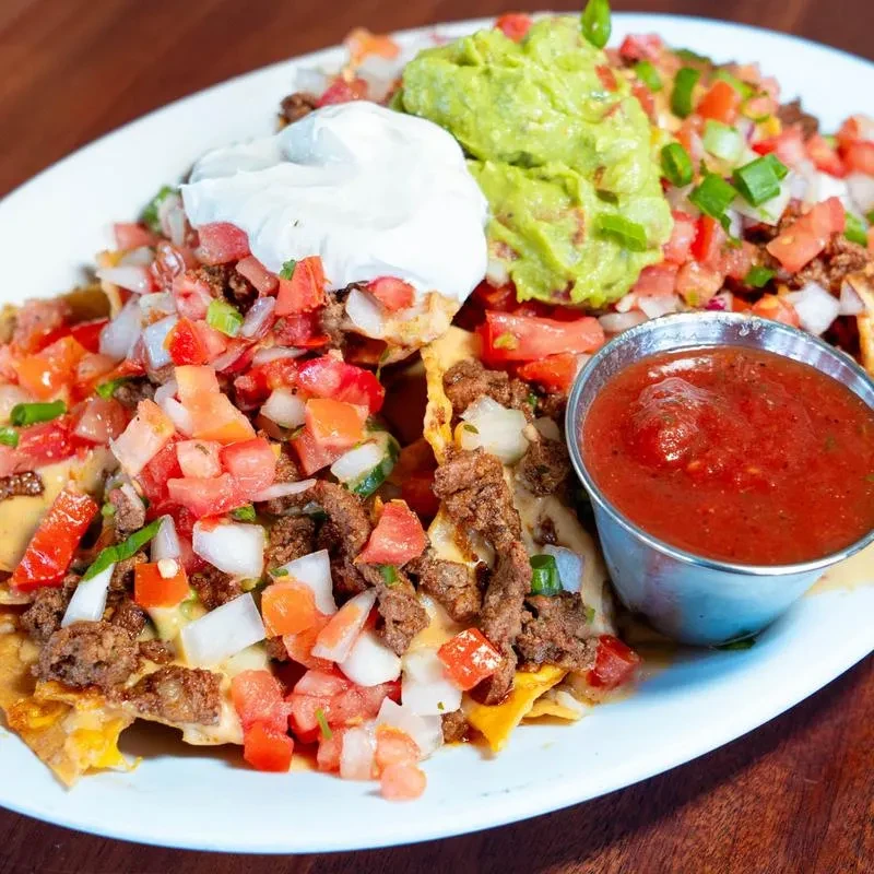Large nachos topped with cheese, meat, pico, sour cream, and guacamole.
